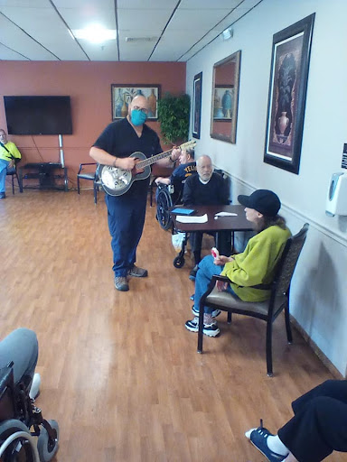 A musician entertains residents at a senior center, creating a joyful atmosphere with live music.