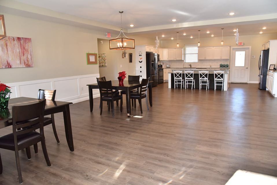 A spacious open floor plan featuring a dining area and a modern kitchen with wood flooring.