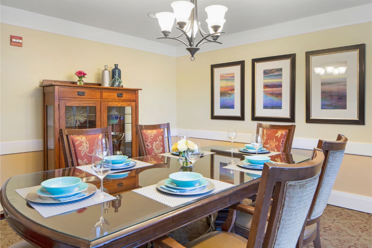 A well-decorated dining room with a modern table setting and art on the walls.