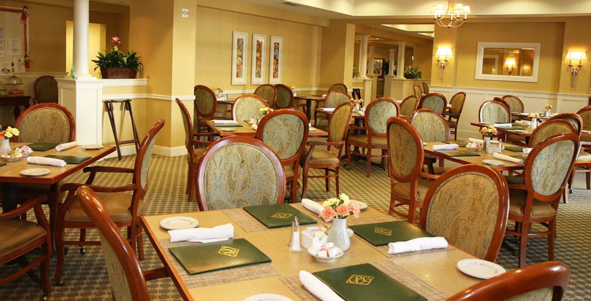 A well-arranged dining room in a restaurant with neatly set tables and classic decor.