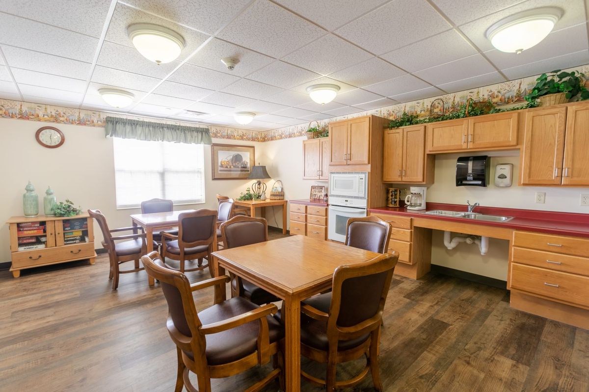 A cozy dining area with wooden furniture and a kitchen setup.