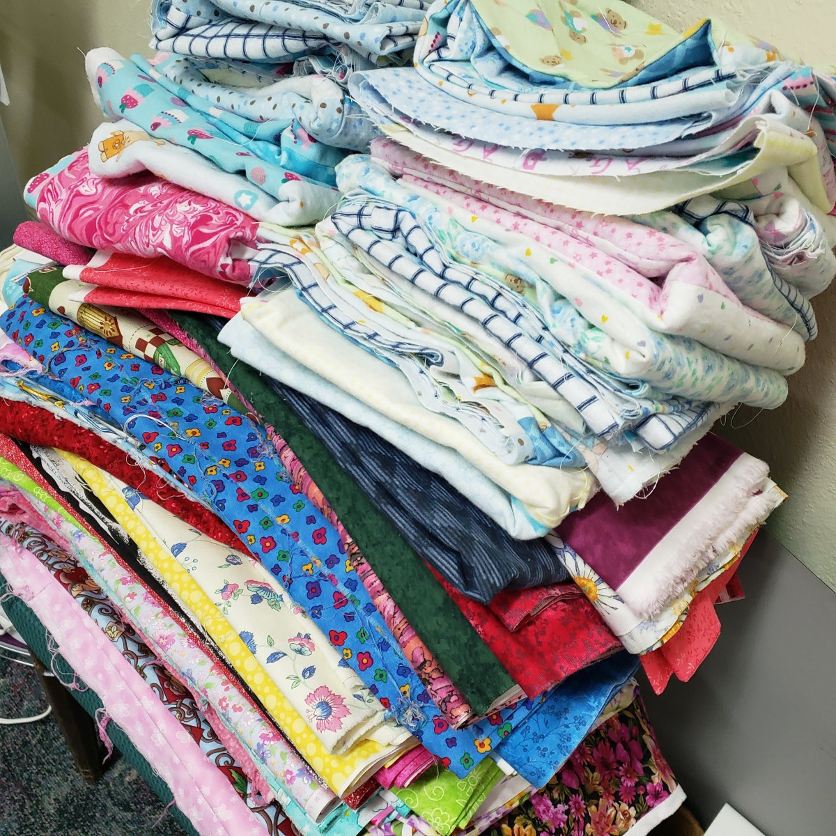A neatly stacked pile of colorful and patterned fabric pieces.