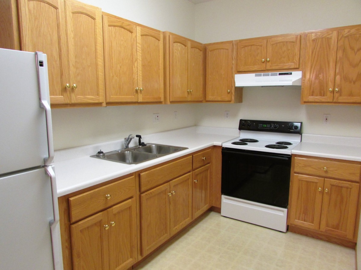 A modern kitchen with wooden cabinets and a clean countertop.