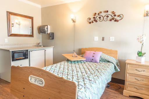 A cozy hospital room equipped with a patient bed, decorative accents, and essential amenities.