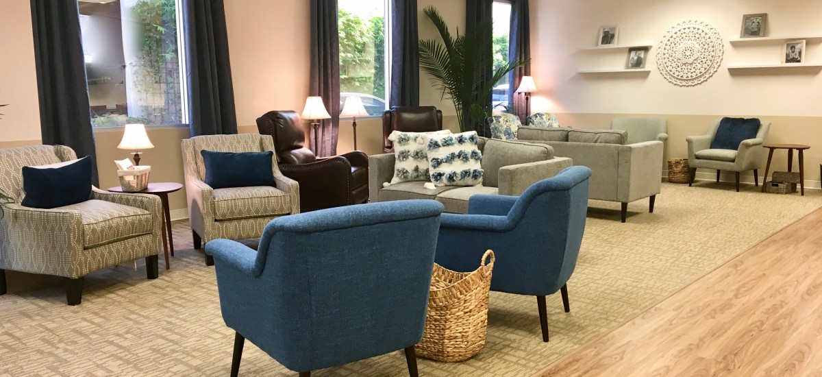 A cozy living room area featuring various chairs, sofas, lamps, and decor.
