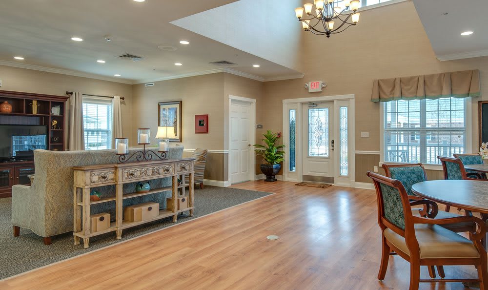 A spacious and elegantly decorated foyer with wood flooring and a chandelier.