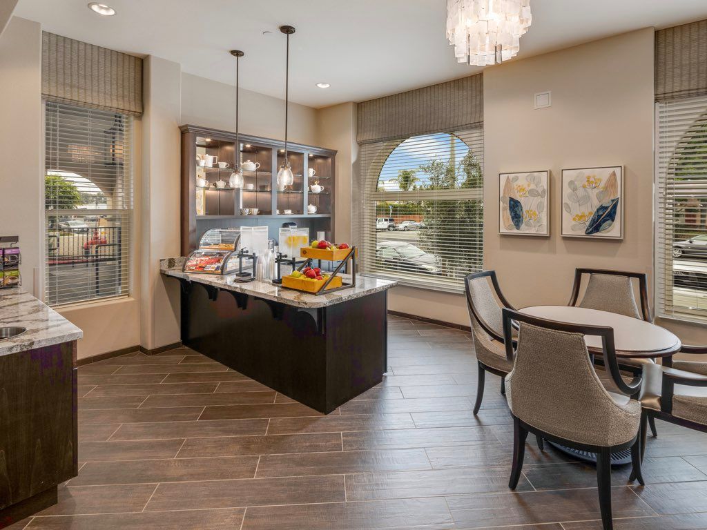 A modern dining area featuring a kitchen island with pendant lights, seating, and elegant decor.