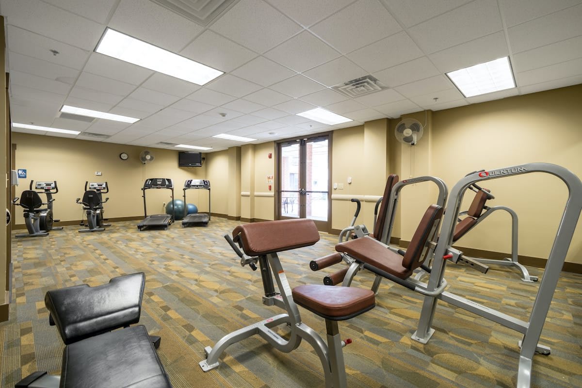 A small gym with exercise machines and treadmills.