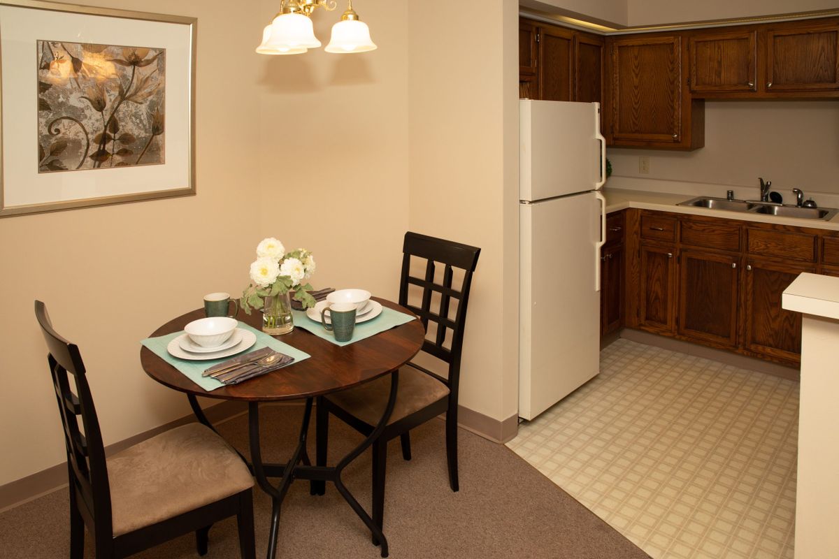 A cozy dining area with a neatly set table adjacent to a kitchen.