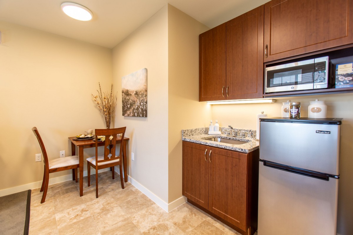 A cozy kitchenette with a dining area in a modern apartment setting.