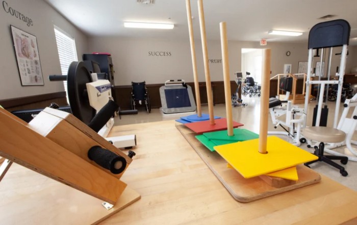 A physical therapy room equipped with various exercise equipment for rehabilitation.