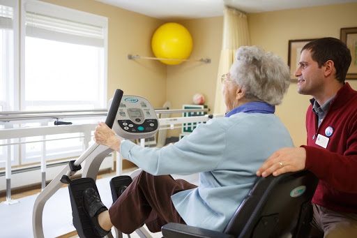 An elderly individual participating in a rehabilitation exercise on a stationary bike, promoting health and fitness.