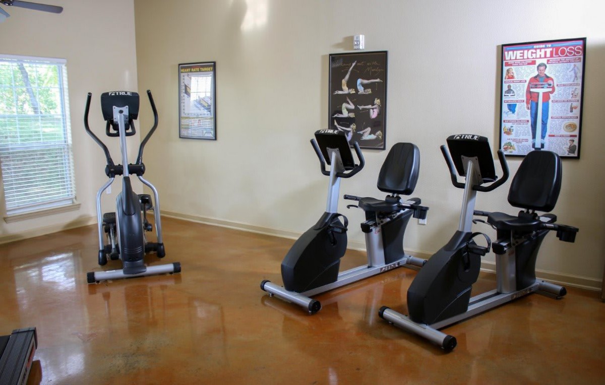 A fitness room with stationary bikes and an elliptical machine.