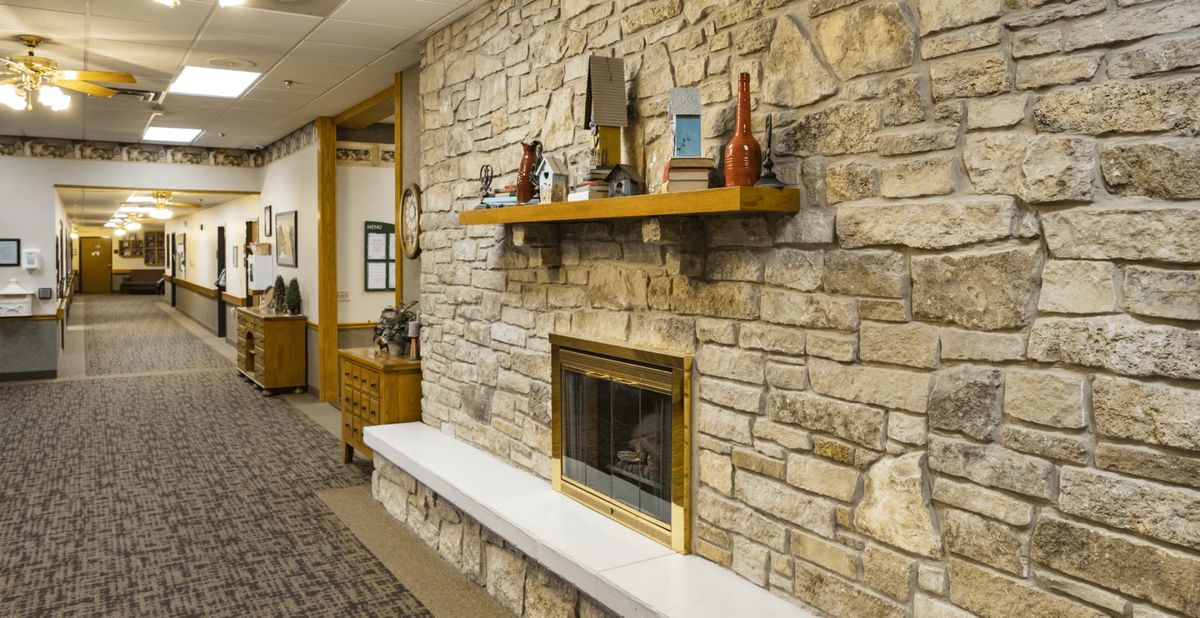A cozy stone fireplace adorned with decorative items on a wooden mantel.