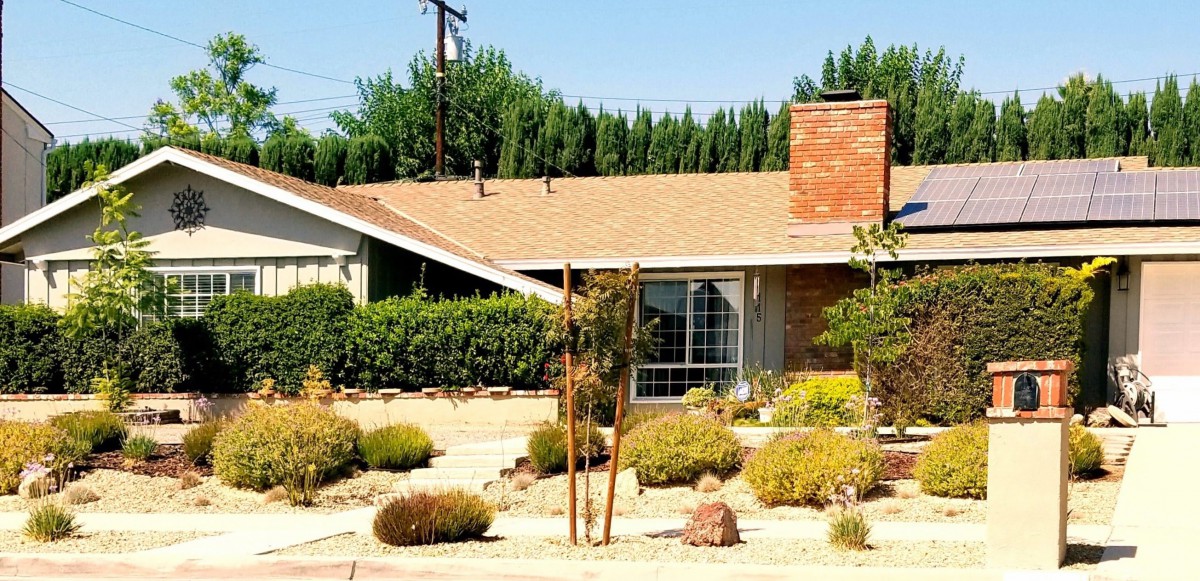A suburban house with a well-maintained yard and chimney.