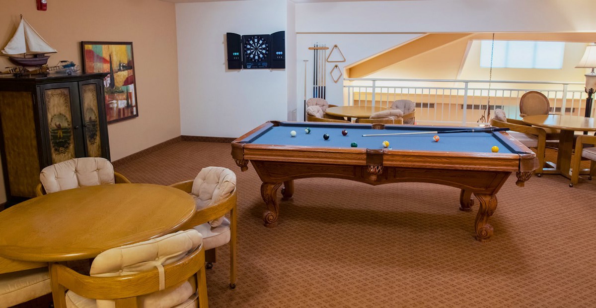 A cozy game room featuring a pool table and a dartboard, perfect for leisure activities.