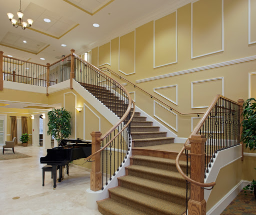 An elegant interior featuring a grand staircase and a piano, showcasing luxury design.