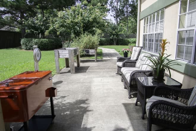 A cozy patio with outdoor seating and lush garden views.