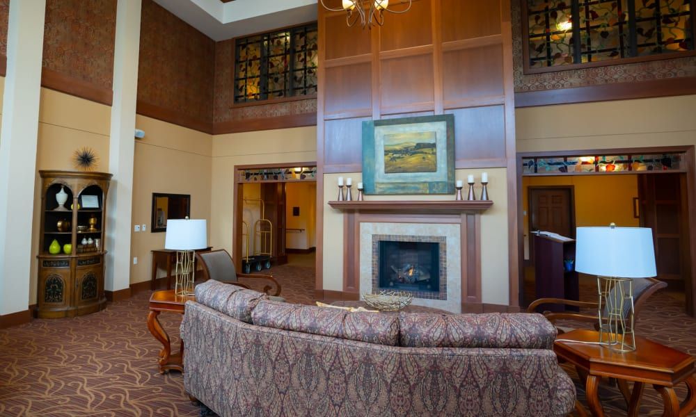 A cozy living room with a fireplace, comfortable sofa, and elegant artwork above the mantel.
