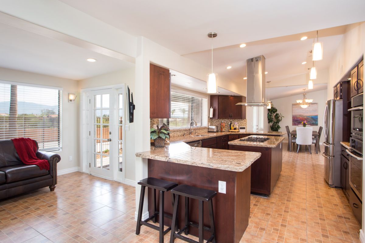 A modern kitchen with a central island and wood cabinets.