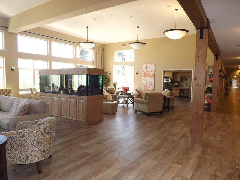 A spacious and well-lit living area with comfortable seating, a large aquarium, and expansive windows.