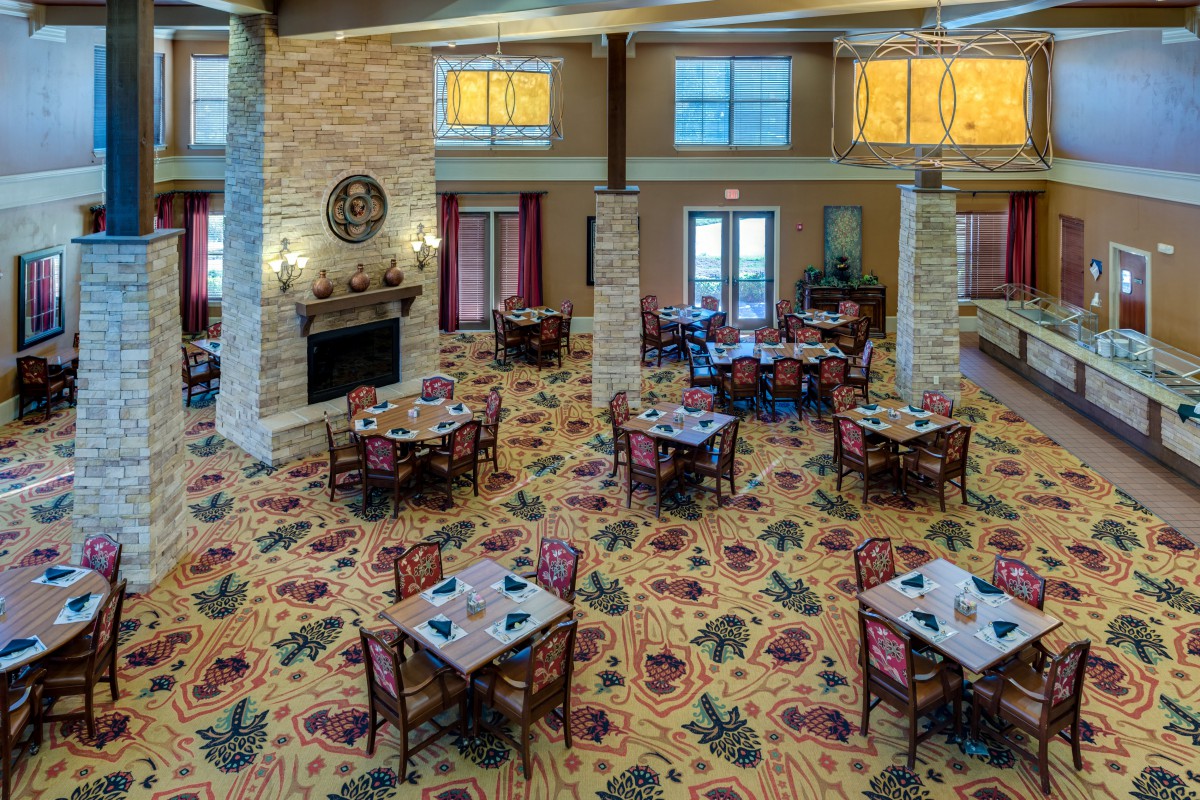 Elegant dining area with neatly arranged tables and a cozy fireplace.