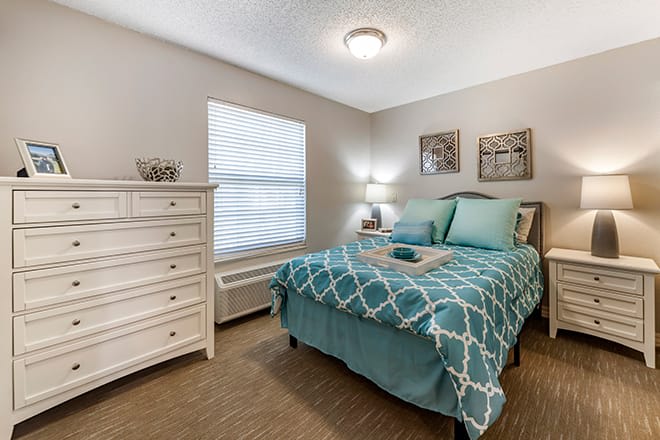 A cozy bedroom with modern decor featuring a neatly made bed and a white dresser.