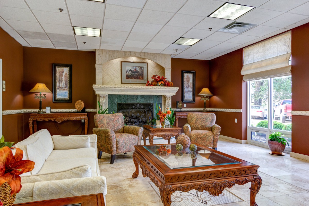 A cozy living room with comfortable seating and a fireplace, featuring traditional decor.