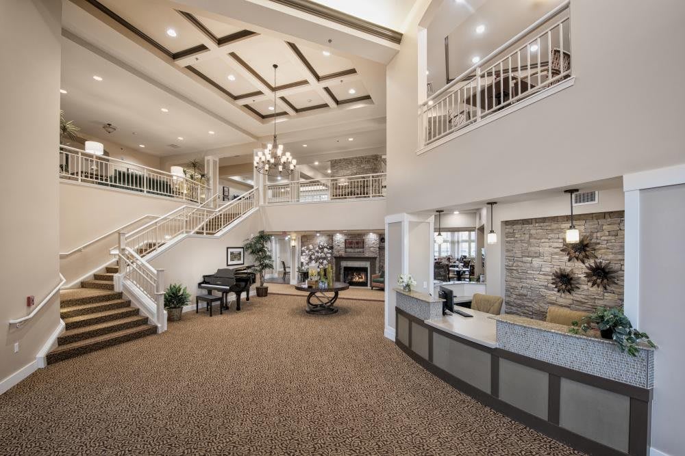 A spacious and elegantly designed lobby with a grand staircase and chandelier.