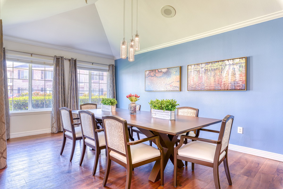 A bright dining room with a large table, chairs, and stylish decor.