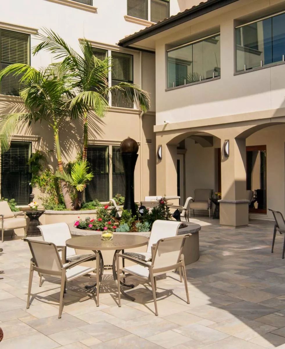 A spacious patio with outdoor furniture and lush greenery.