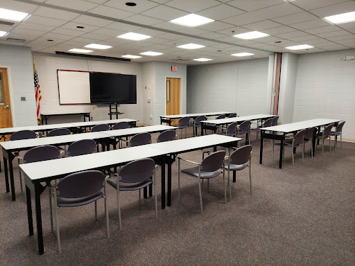 A spacious conference room set up with tables and chairs, ready for a meeting or presentation.