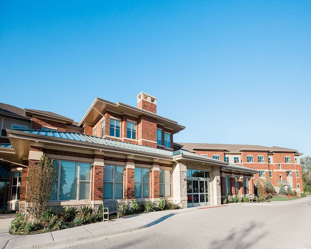 A modern brick building with large windows and a clear blue sky overhead.