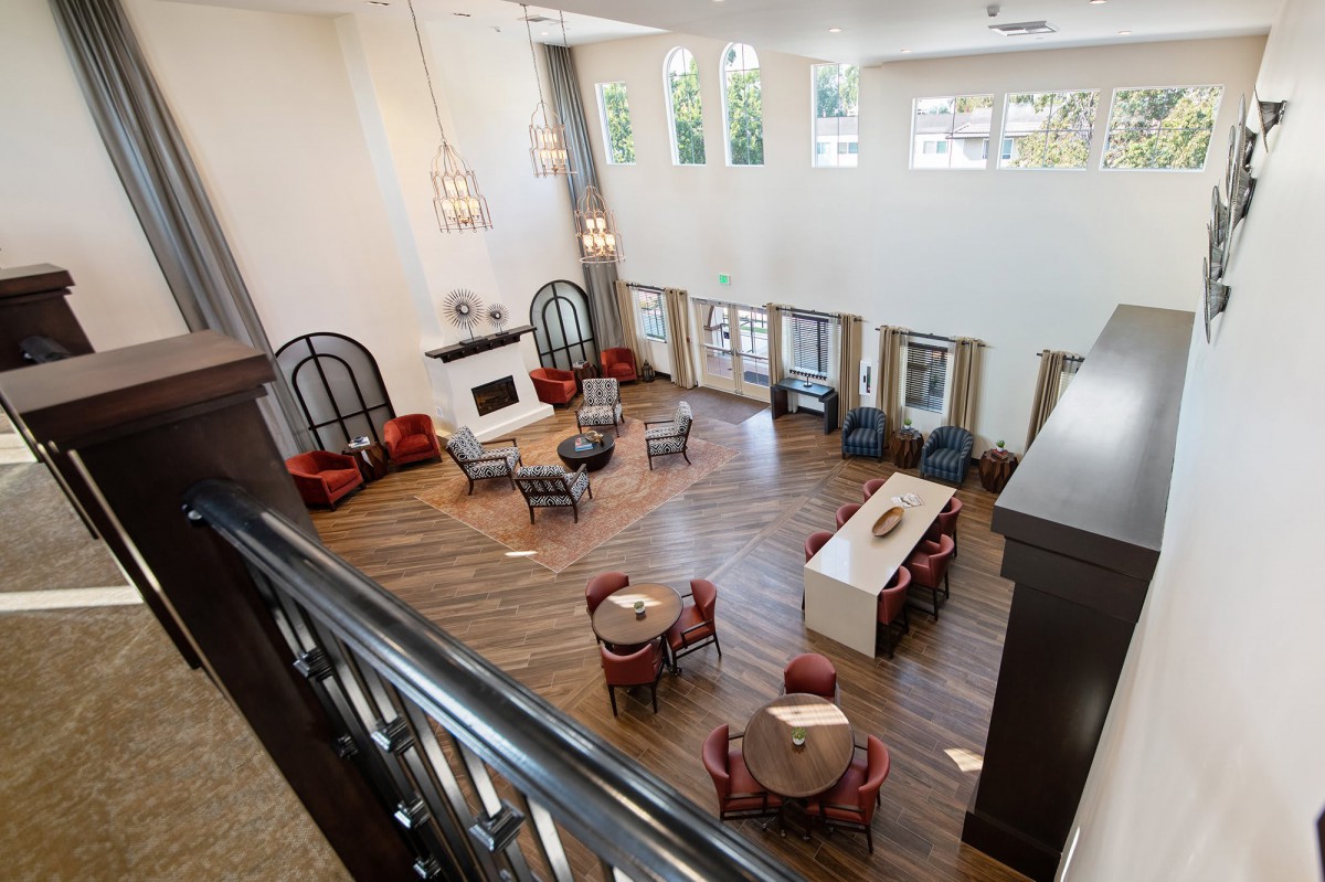 A spacious and elegant lobby featuring a high ceiling, modern chandeliers, and comfortable seating areas.