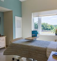 A bright and cozy bedroom with a large window allowing natural light to flood in.