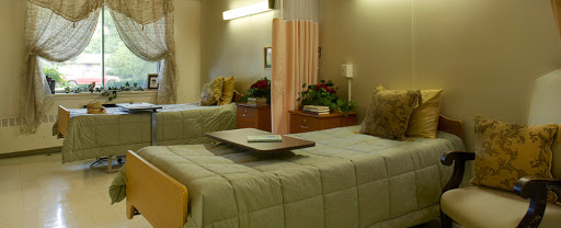 A cozy hospital room featuring two patient beds, designed for comfort and privacy.