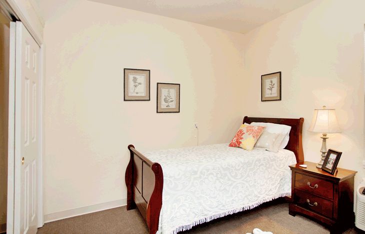 A cozy bedroom with a single bed and framed artwork on the wall.