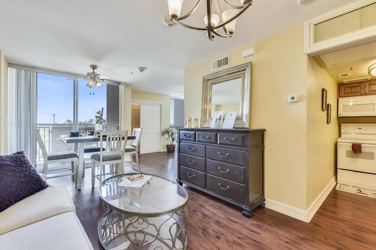 A bright and spacious living and dining area featuring elegant furniture and ample natural light.