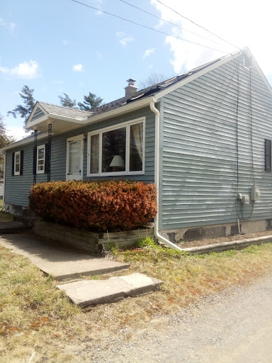 A charming single-story house with blue siding and a well-maintained front yard.