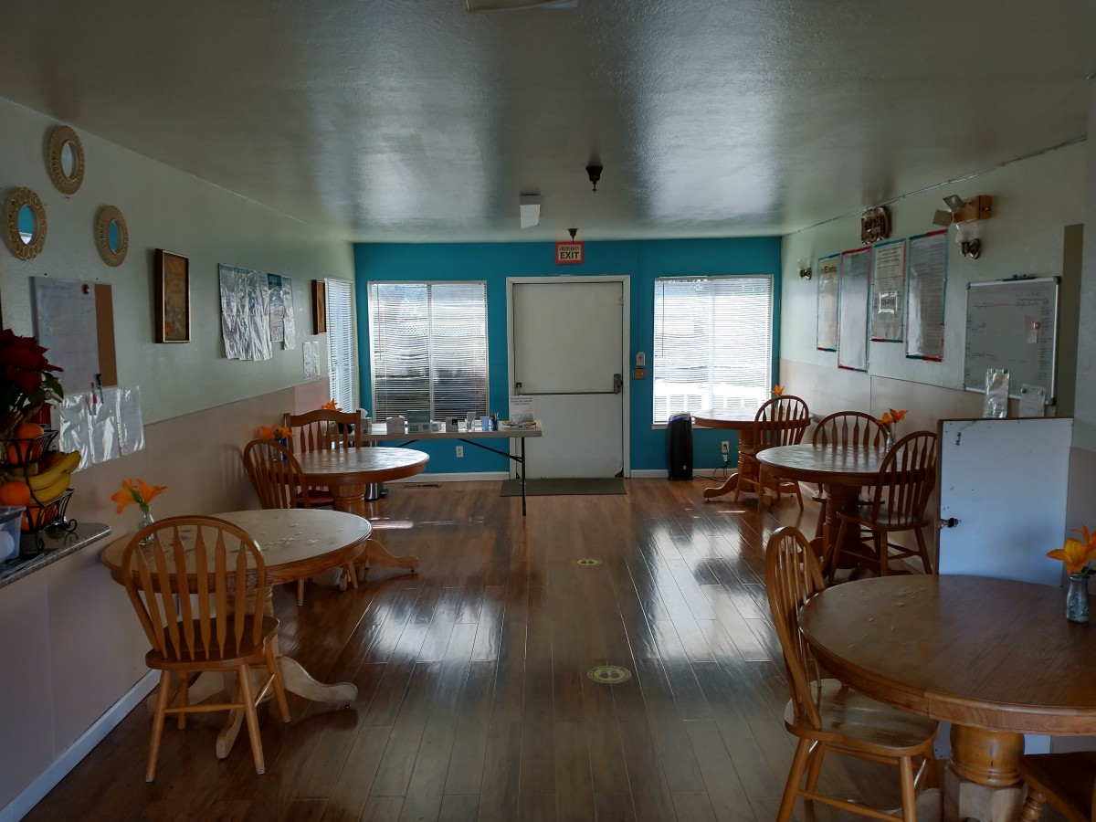 An empty cafe interior with wooden tables and chairs.