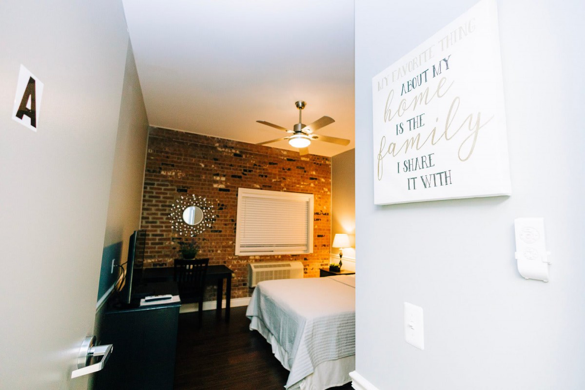 A cozy modern bedroom with a brick accent wall and minimalist decor.
