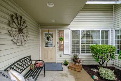 A welcoming front porch featuring a bench, potted plants, and decorative elements around the door.