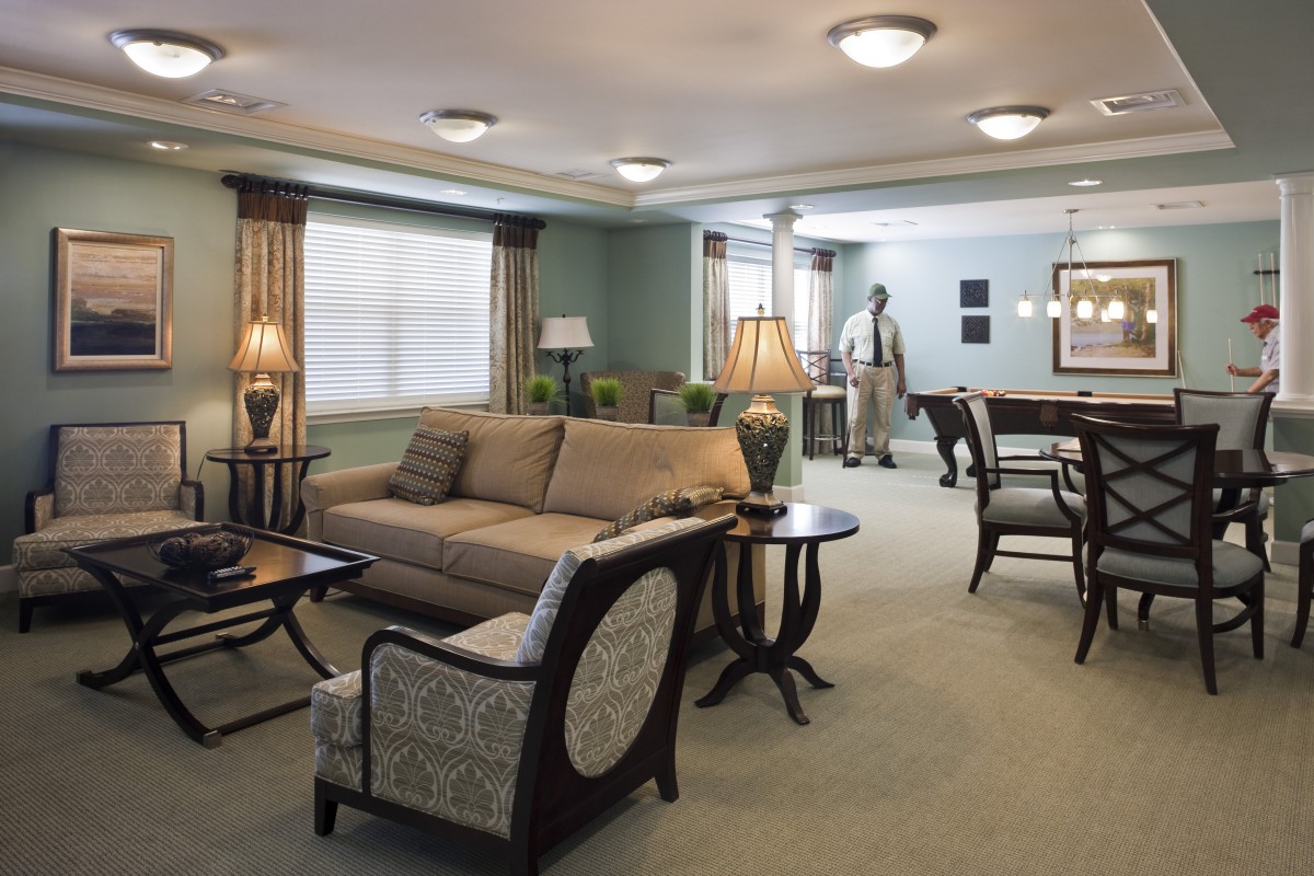 A well-furnished living room with a sofa, chairs, coffee table, and elegant lamps.