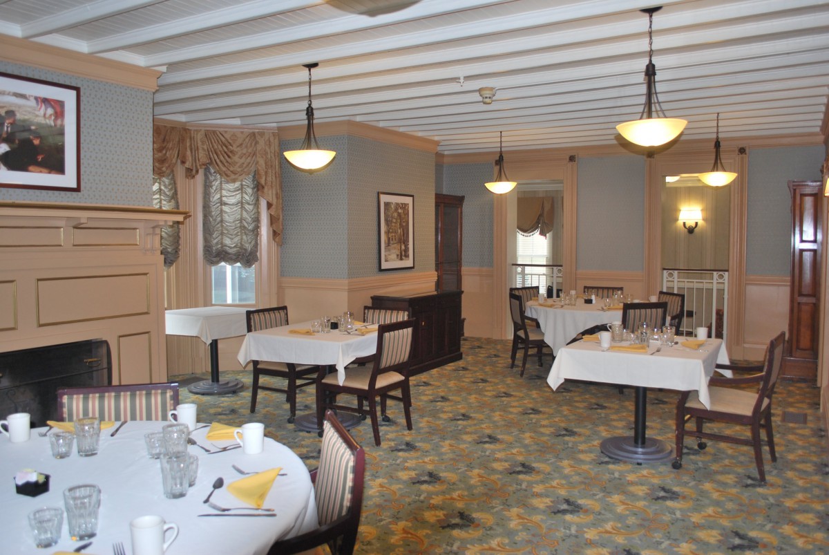A cozy restaurant dining room with neatly arranged tables and warm lighting.