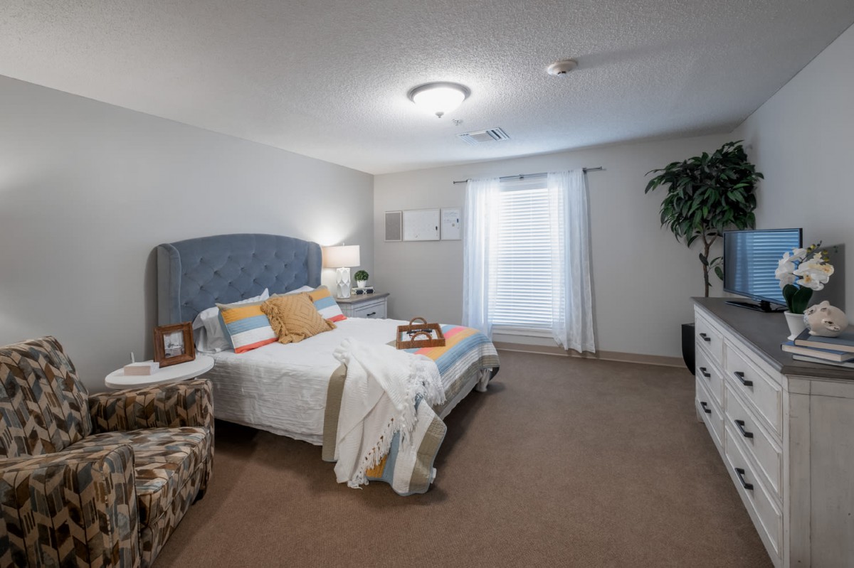 A cozy bedroom with a neatly made bed, soft lighting, and tasteful decor.