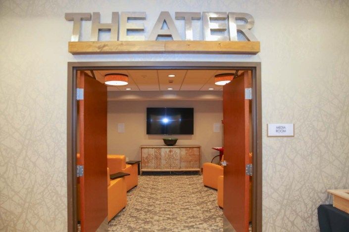 An entrance to a theater with a modern lounge area featuring cozy seating and contemporary design.