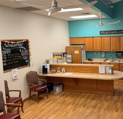 A cozy reception area with a small kitchenette and seating.
