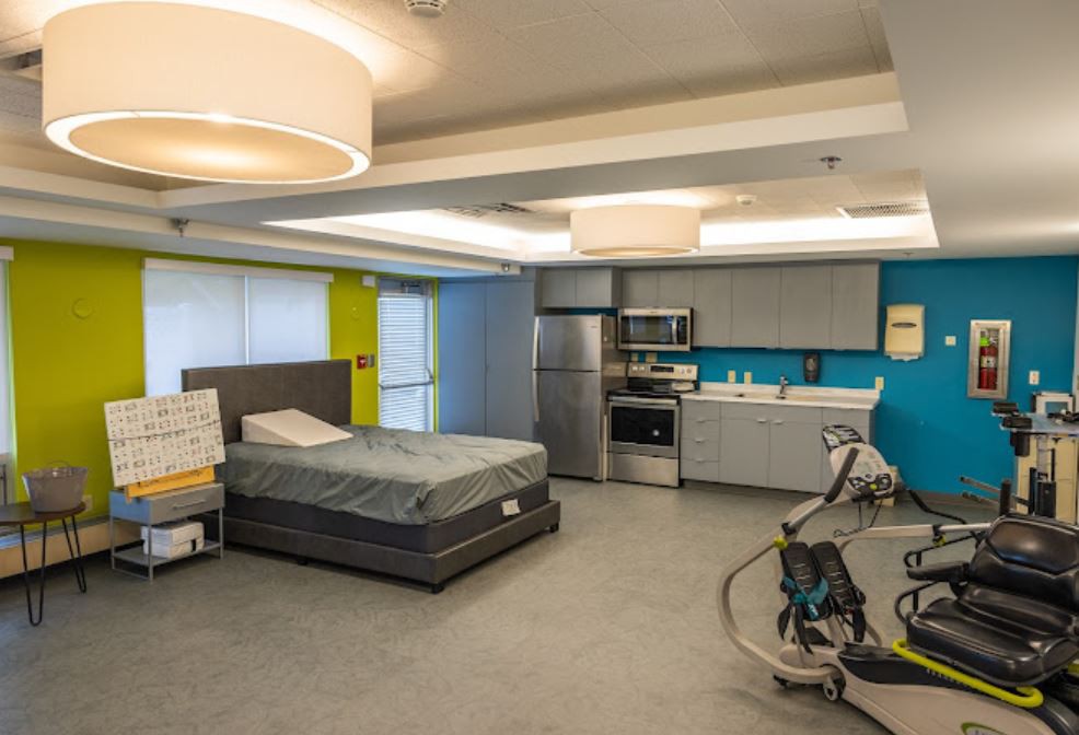 A modern room featuring a bed and integrated kitchen area.