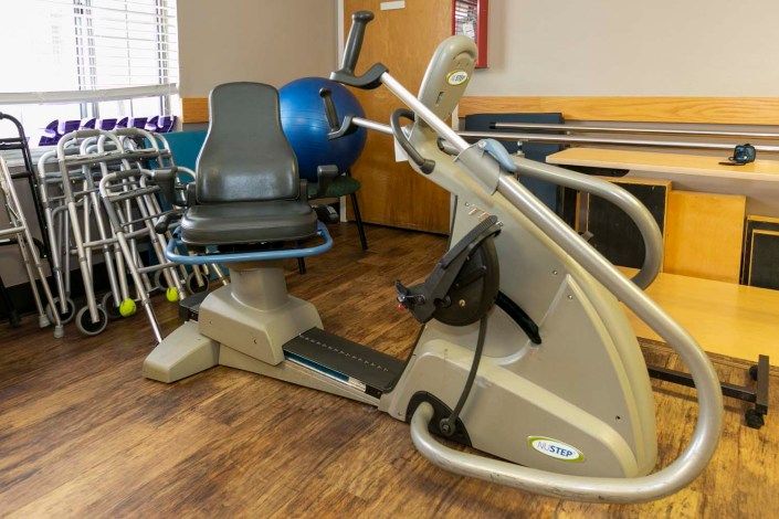A recumbent exercise bike in a rehabilitation facility setting.