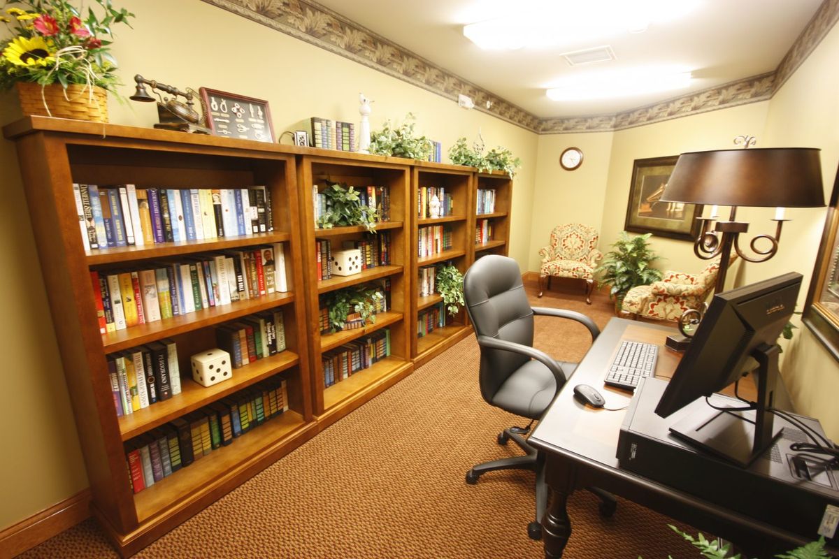 A cozy office with bookshelves, a desk, and a computer.